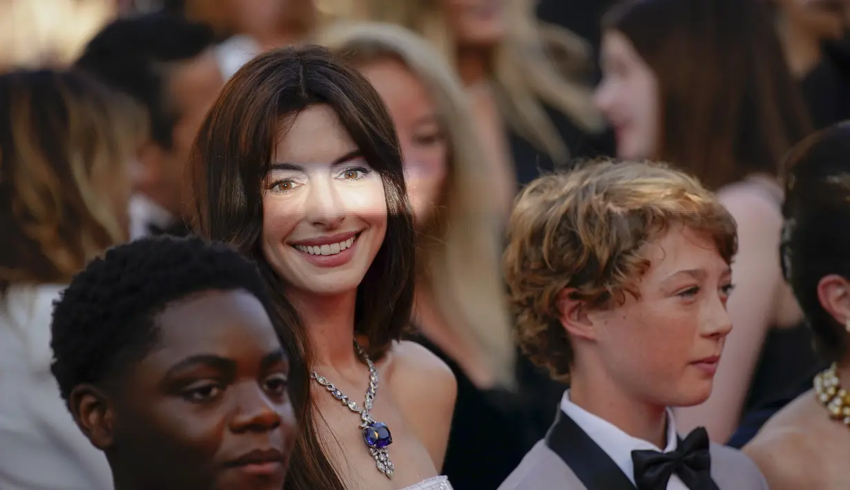 <p>Anne Hathaway (tengah) berpose dengan Jaylin Webb (kiri) dan Michael Banks Repeta saat tiba di pemutaran perdana film 'Armageddon Time' di festival film internasional ke-75, Cannes, Prancis selatan (19/5/2022). (AP Photo/Daniel Cole)</p>