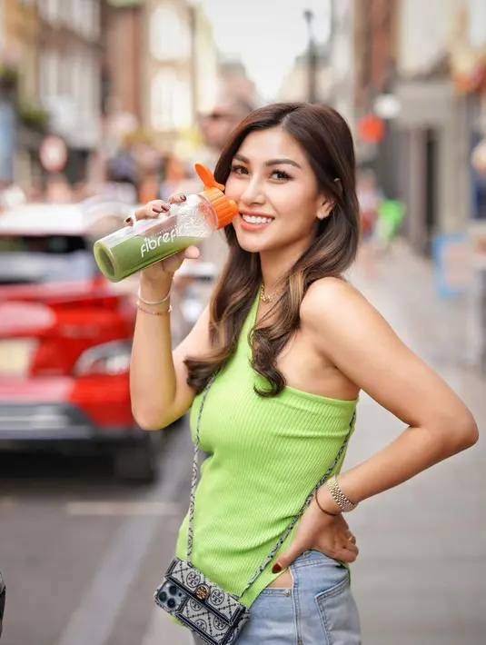 Nisya Ahmad  saat sedang meminum di sebuah jalan di London. Ibu tiga anak itu terlihat memiliki tubuh yang ramping bak anak gadis. Dia tersenyum sumringah melemparkan lirikan ke kamera. Rambutnya yang indah, pesona kecantikan Nisya pun kian bertambah. (Instagram/nissyaa)