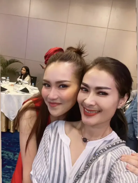 Iis Dahlia bersama sang suami hadir mengenakan atasan bergaris abu putih. Dengan kalung keemasannya serta lipstik merah boldnya. @isdadahlia