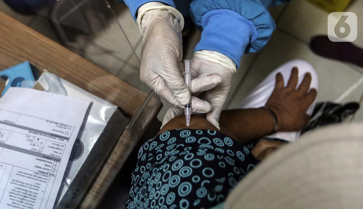 Tenaga kesehatan menyuntikkan vaksin COVID-19 dosis ketiga kepada warga saat pelaksanaan vaksinasi booster COVID-19 di Puskesmas Cilandak, Jakarta, Rabu (12/1/2022). Pemerintah mulai program vaksinasi booster COVID-19 gratis untuk masyarakat umum berusia 18 tahun ke atas. (Liputan6.com/Johan Tallo)