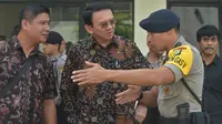 Gubernur DKI Jakarta nonaktif, Basuki Tjahaja Purnama (Ahok) mendengarkan penjelasan seorang polisi terkait rencana meninggalkan PN Jakarta Utara, Selasa (20/12). Sebelumnya Ahok menjalani sidang kedua kasus dugaan penistaan. (REUTERS/Adek BERRY/Pool)