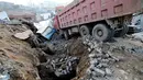 Ledakan hebat ini mampu membelah permukaan tanah sampai beberapa meter. Tampak truk yang terparkir terperosok ke dalam lubang saat ledakan terjadi (China Out/AFP Photos)