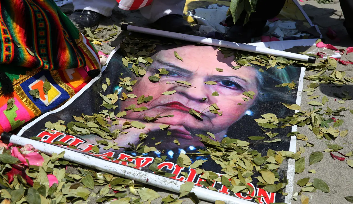 Dukun Peru melemparkan daun koka ke atas poster bergambar Capres AS dari Partai Demokrat, Hillary Clinton, saat melakukan ritual prediksi menjelang pemilihan presiden AS, di Lima, Peru, Senin (7/11). (REUTERS/Mariana Bazo)