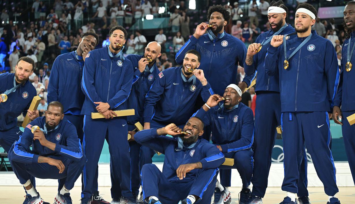 Tim basket Amerika Serikat berfoto bersama setelah berhasil mendapatkan medali emas Olimpiade Paris 2024 setelah mengalahkan Prancis dengan skor 98-87 pada pertandingan final yang berlangsung di Bercy Arena, Paris, Prancis, Minggu (11/08/2024) dini hari WIB. (AFP/Damien Meyer)