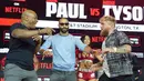 Aksi Mike Tyson ini tampak membuat Jake Paul geram, meski diketahui hanya sekadar candaan. Jake Paul pun kemudian gantian mendorong Mike Tyson. Tetapi, Mike Tyson menanggapinya dengan tertawa. (AFP/Timothy A. Clary)