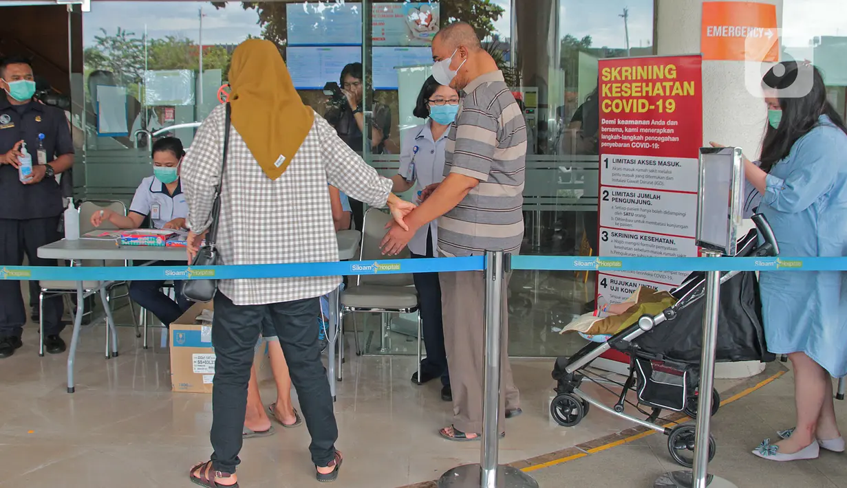 Pengunjung melewati akses skrining kondisi sebelum memasuki Rumah Sakit Siloam, Jakarta, Sabtu (7/3/2020). RS Siloam menyediakan fasilitas tenda isolasi sementara, ruangan dekontaminasi dan pengecekan suhu tubuh guna mengantisipasi penyebaran virus corona COVID-19. (Liputan6.com/Herman Zakharia)