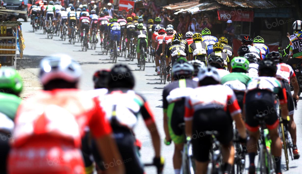 Para pebalap melintasi etape ke-5 Tour de Singkarak, Pantai Carocok-Painan menuju pantai Gondoriah-Pariaman, Sumatera Barart. (Bola.com/Nicklas Hanoatubun)