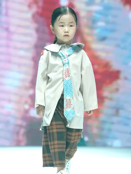 Model cilik menampilkan kreasi busana dalam sebuah peragaan busana di Hangzhou, China (24/8/2020). Peragaan busana tersebut diadakan sebagai bagian dari ajang China International Kids Fashion Week yang sedang berlangsung saat ini, menampilkan tren mode untuk pakaian anak-anak. (Xinhua/Chen Jianli)