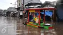 Pedagang Ketoprak menerobos banjir di kawasan Pasar Buncit, Jakarta Selatan, Selasa (9/2/2016). Banjir menggenangi kawasan tersebut hingga setinggi 100 cm akibat luapan Kali Kemang. (Liputan6.com/Gempur M Surya)