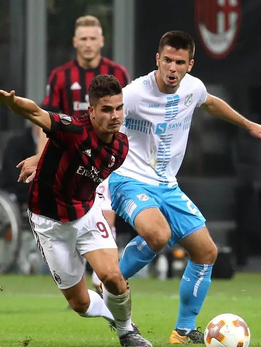 Striker AC Milan, Andre Silva, berebut bola dengan striker Rijeka, Domagoj Pavicic, pada laga Liga Europa di Stadion San Siro, Milan, Kamis (28/9/2017). AC Milan menang 3-2 atas  Rijeka. (AP/Matteo Bazzi)