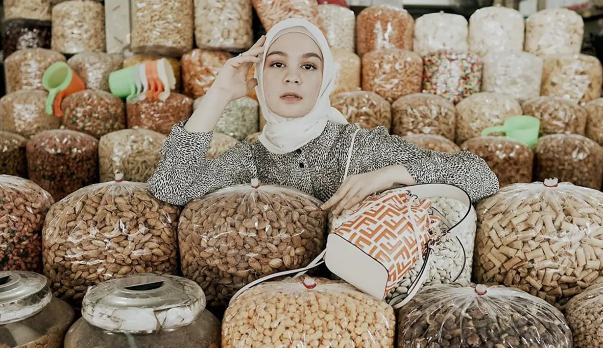 Berbeda dari yang lain, influencer sekaligus desainer ini memilih foto di lapak makanan kering. Seolah menyatu dengan lapak, ia tampil menawan dengan baju bermotif hitam putih dan slingbag. (Liputan6.com/IG/@tantrinamirah)