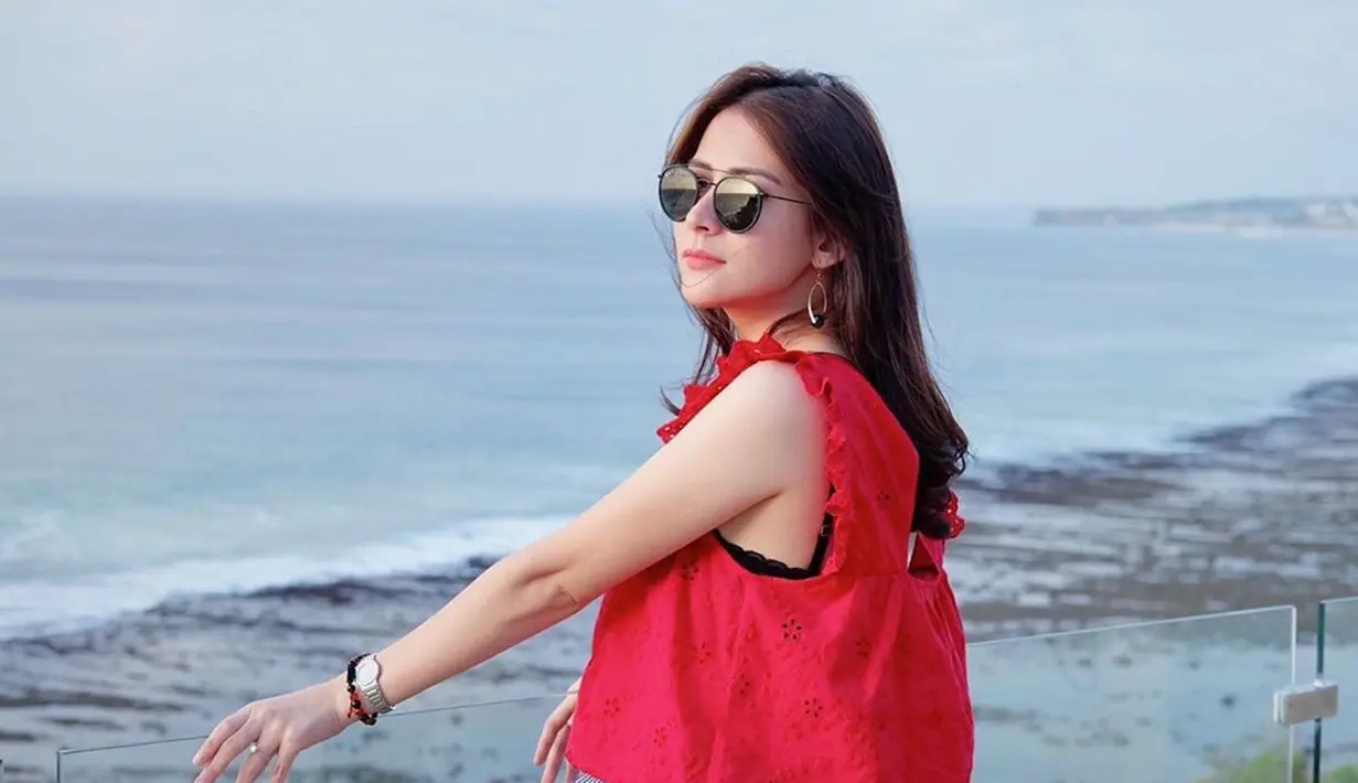 Rina Diana menikmati pemandangan pantai dengan gaya yang trendi. Selain baju warna merah, ia juga memakai kacamata hitam. Memesonanya aktris hits FTV ini selalu berhasil membuat publik terkesima dengan gaya penampilannya. (Liputan6.com/IG/@rinadiana_8)