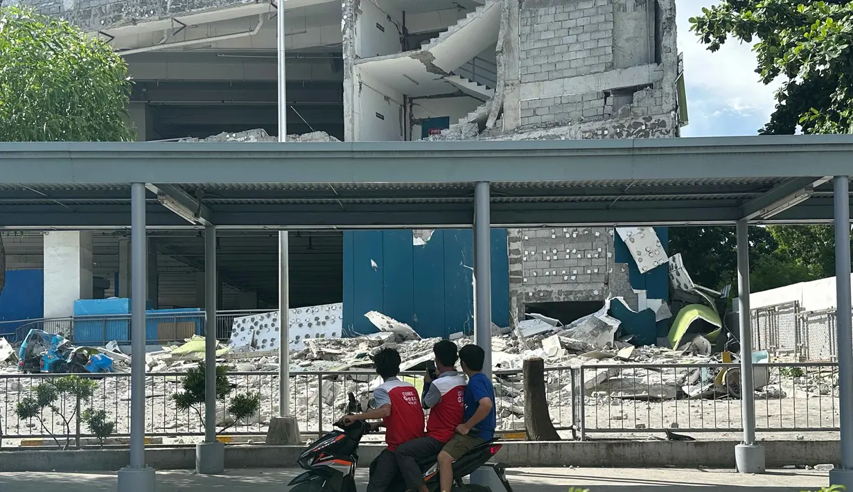 Orang-orang melihat bangunan yang runtuh akibat gempa bumi di kota General Santos, Filipina, Senin 8 Juni 2026. (AP Photo)