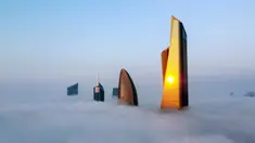 Foto udara memperlihatkan pemandangan Al Hamra Tower (kanan), Kantor Pusat Bank Nasional Kuwait, dan Al Rayah Tower (kiri kedua) di tengah kabut tebal, Kuwait City, 21 Januari 2023. Al Hamra Tower adalah gedung tertinggi ke-23 di dunia dan tergolong bangunan baru di Kuwait City. (YASSER AL-ZAYYAT/AFP)