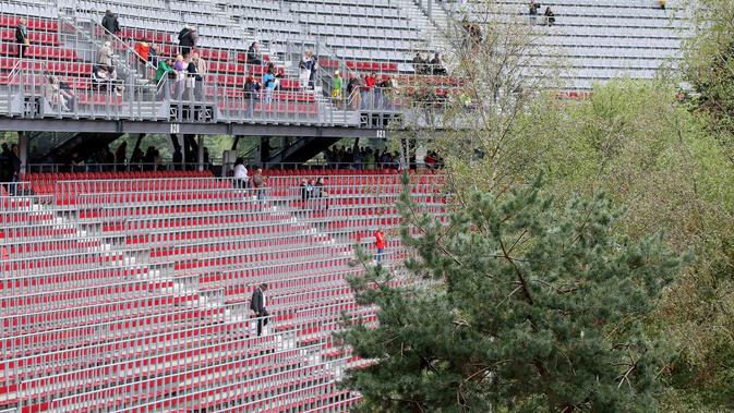 Pengunjung melihat instalasi ekosistem hutan di Stadion Woerthersee, Austria, Minggu (8/9/2019). Sampai karya seni itu selesai dipamerkan, Klub divisi dua Austria, SK Klagenfurt sementara harus mengungsi di stadion kecil di dekatnya. (AP/Ronald Zak)