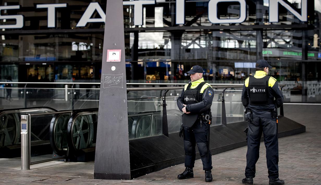 Aparat kepolisian berjaga di pintu masuk sebuah stasiun di Rotterdam, Senin (18/3). Pihak keamanan di Belanda meningkatkan keamanan di bandara dan bangunan penting lainnya usai penembakan di Utrecht yang menewaskan 3 orang.  (KOEN VAN WEEL/ANP/AFP)