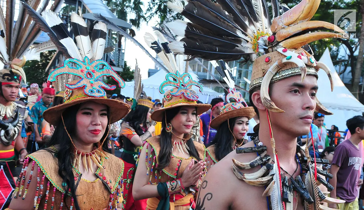 Sejumlah orang mengenakan pakaian adat melakukan pawai festival Budaya Borneo di Car Free Day, Jakarta, Minggu (30/7). Festival tersebut dalam rangka mengenalkan adat dan budaya borneo melalui pakaian dan musiknya. (Liputan6.com/Helmi Afandi)