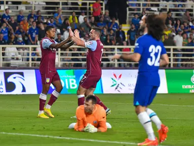 Gelandang Aston Villa, John McGinn (tengah) merayakan dengan rekan setimnya setelah mencetak gol ke gawang Chelsea selama pertandingan uji coba di Stadion al-Nahyan di Abu Dhabi (11/12/2022). Aston Villa menang tipis atas Chelsea dengan skor 1-0. (AFP/Ryan Lim)