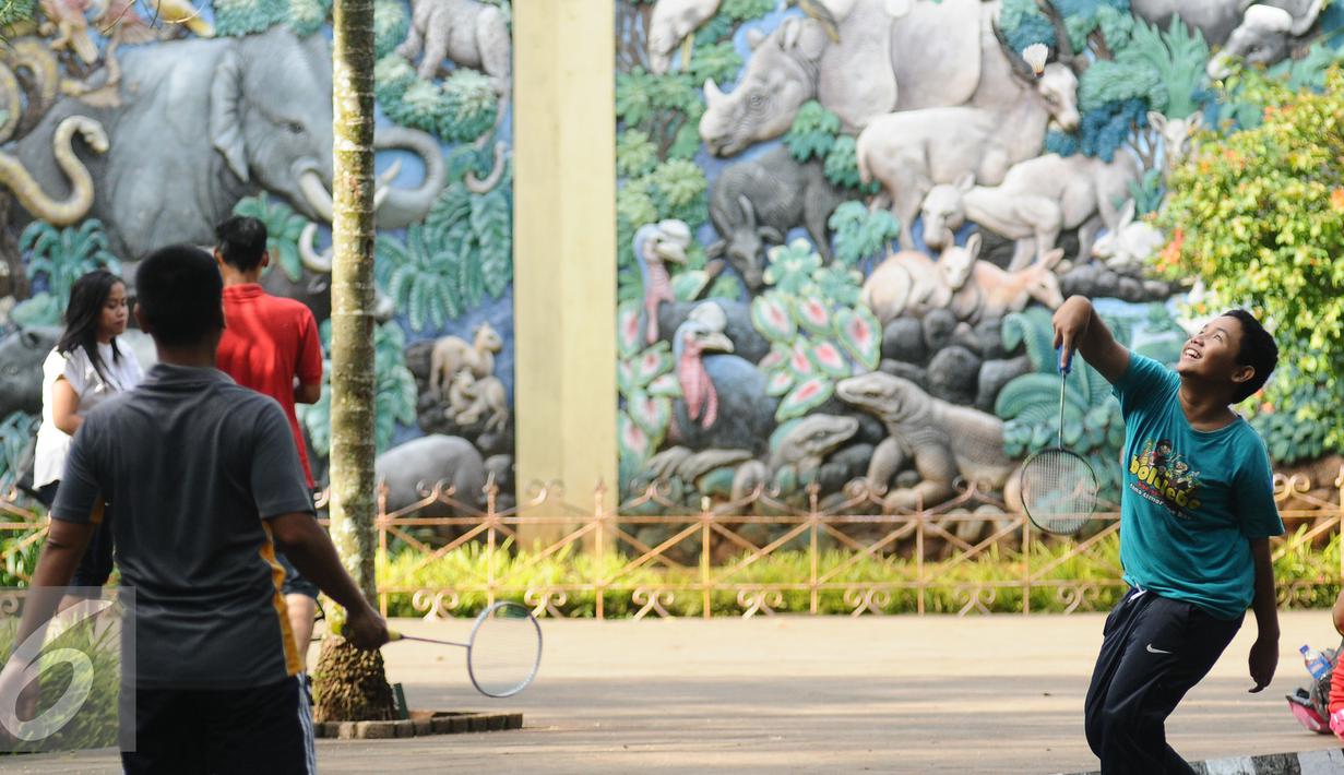 Warga berolahraga bulutangkis di sekitar kawasan Kebun Binatang Ragunan, Jakarta, Minggu (9/10). Kawasan KBR menjadi salah satu lokasi alternatif warga Jakarta untuk berolahraga pada Minggu pagi. (Liputan6.com/Helmi Fithriansyah)