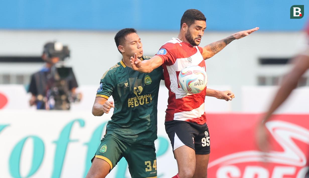 <p>Pemain Madura United, Junior Brandao, berebut bola dengan pemain Persikabo 1973, Andy Setyo, dalam laga pekan kesembilan BRI Liga 1 2023/2024 di Stadion Wibawa Mukti, Cikarang, Sabtu (19/8/2023). (Bola.com/Abdul Aziz)</p>