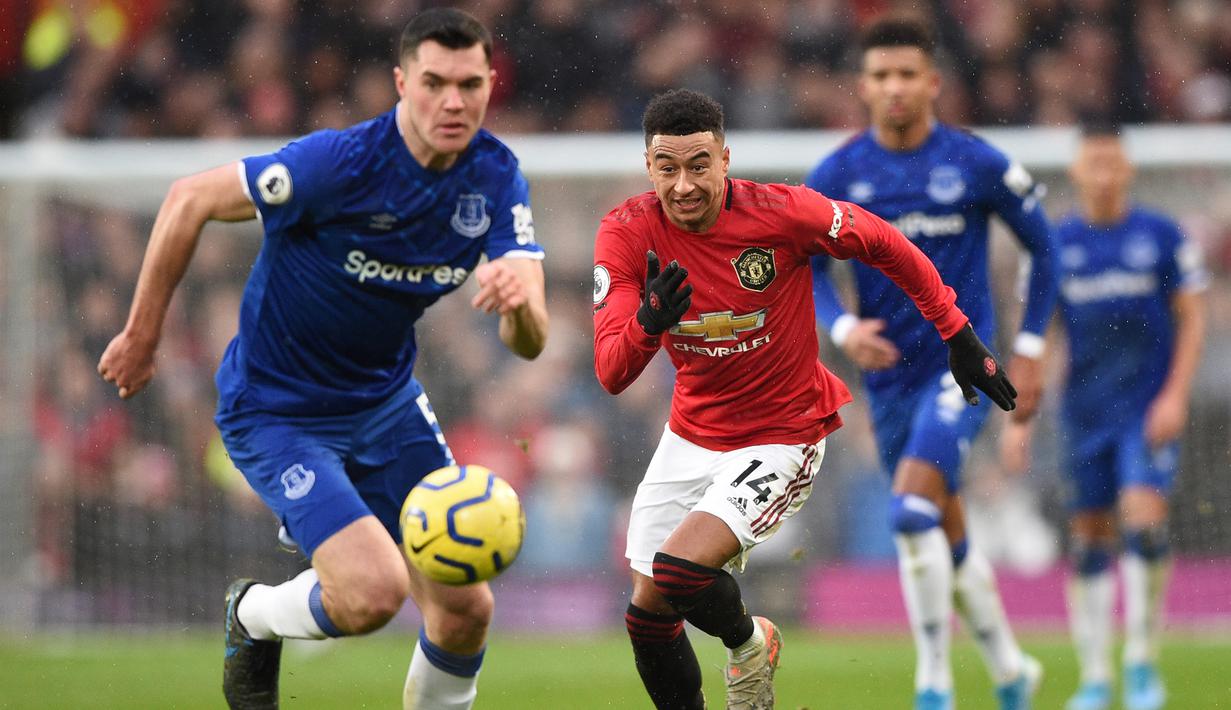 Gelandang Manchester United, Jesse Lingard, beradu cepat dengan bek Everton, Michael Keane, pada laga Premier League di Stadion Old Trafford, Manchester, Minggu (15/12). Kedua klub bermain imbang 1-1. (AFP/Oli Scarff)