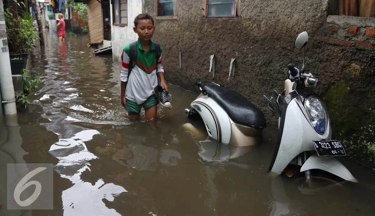 Seorang anak melitasi banjir di kawasan Jatayu, Jakarta, Senin (21/11). Banjir disebabkan tingginya curah hujan dan buruknya saluran air serta meluapnya Kali Pesanggrahan. (Liputan6.com/Gempur M. Surya)