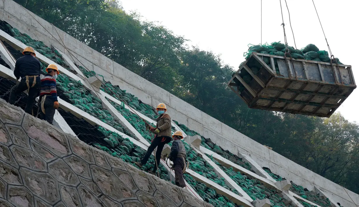 Para pekerja sedang meletakkan kantong-kantong ramah lingkungan berisi tanah dan benih di sebuah lereng untuk gelaran Olimpiade Musim Dingin Beijing 2022 di Distrik Yanqing, Beijing, ibu kota China (28/9/2020). (Xinhua/Zhang Chenlin)