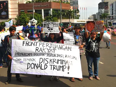 Sejumlah masa yang tergabung dalam front Perjuangan Rakyat membentangkan spanduk dan membawa poster saat melakukan aksi yang mengecam kebijakan Presiden Amerika Serikat Donald Trump di Jakarta, Minggu (5/2). (Liputan6.com/Angga Yuniar)