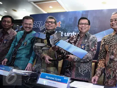 Direktur Utama BRI Asmawi Syam (kedua kanan) menunjukan replika Satelit BRISat saat Launching di Bank BRI Pusat, Jakarta, Selasa (31/5/2016). Satelit BRIsat  akan diluncurkan tanggal 8 Juni 2016 (Liputan6.com/Faizal Fanani)
