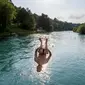 Pemuda melompat untuk berenang di Sungai Aare, lokasi putra Ridwan Kamil, Emmeril Kahn Mumtadz, dilaporkan terseret arus. (FABRICE COFFRINI/AFP)