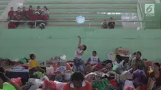 Seorang anak bermain di lokasi pengungsian di GOR Suweca, Klungkung, Bali, Selasa (26/9). Ribuan pengungsi terus berdatangan menyusul peningkatan frekuensi gempa yang mulai dirasakan warga di kawasan Gunung Agung. (Liputan6.com/Gempur M Surya)