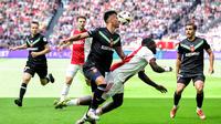 Bek FC Twente, Mees Hilgers berduel dengan striker Ajax Amsterdam dalam laga pekan terakhir Eredivisie 2024/2205 di Johan Cruijff ArenA, Amsterdam, Minggu (18/5/2025). (AFP/Olaf Kraak).
