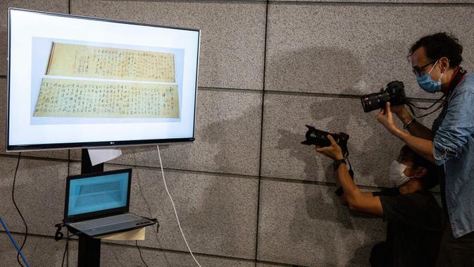 Polisi mengadakan konferensi pers terkait gulungan kaligrafi karya Mao Zedong, yang telah ditemukan, di Hong Kong, 7 Oktober 2020. Pada 10 September 2019, gulungan kaligrafi itu dirampok bersama dengan cap, koin dan karya kaligrafi lainnya yang bernilai total Rp9,5 triliun. (ISAAC LAWRENCE/AFP)