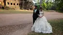 Sepasang pengantin baru melakukan foto pernikahan mereka di kompleks kuil Angkor Wat, sebuah candi ikonik dan bersejarah di Kamboja, 14 Maret 2018. Candi ini dibangun pada pertengahan abad ke-12 dan memakan waktu selama 30 tahun. (AP Photo/Heng Sinith)