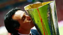 Pelatih Sevilla, Unai Emery mencium trofi di tengah perayaan gelar Liga Europa 2015 di Stadion Narodowy, Polandia, Kamis (28/5/2015). Sevilla memecahkan rekor meraih trofi Liga Europa terbanyak, yakni empat gelar. (Reuters/Kai Pfaffenbach)