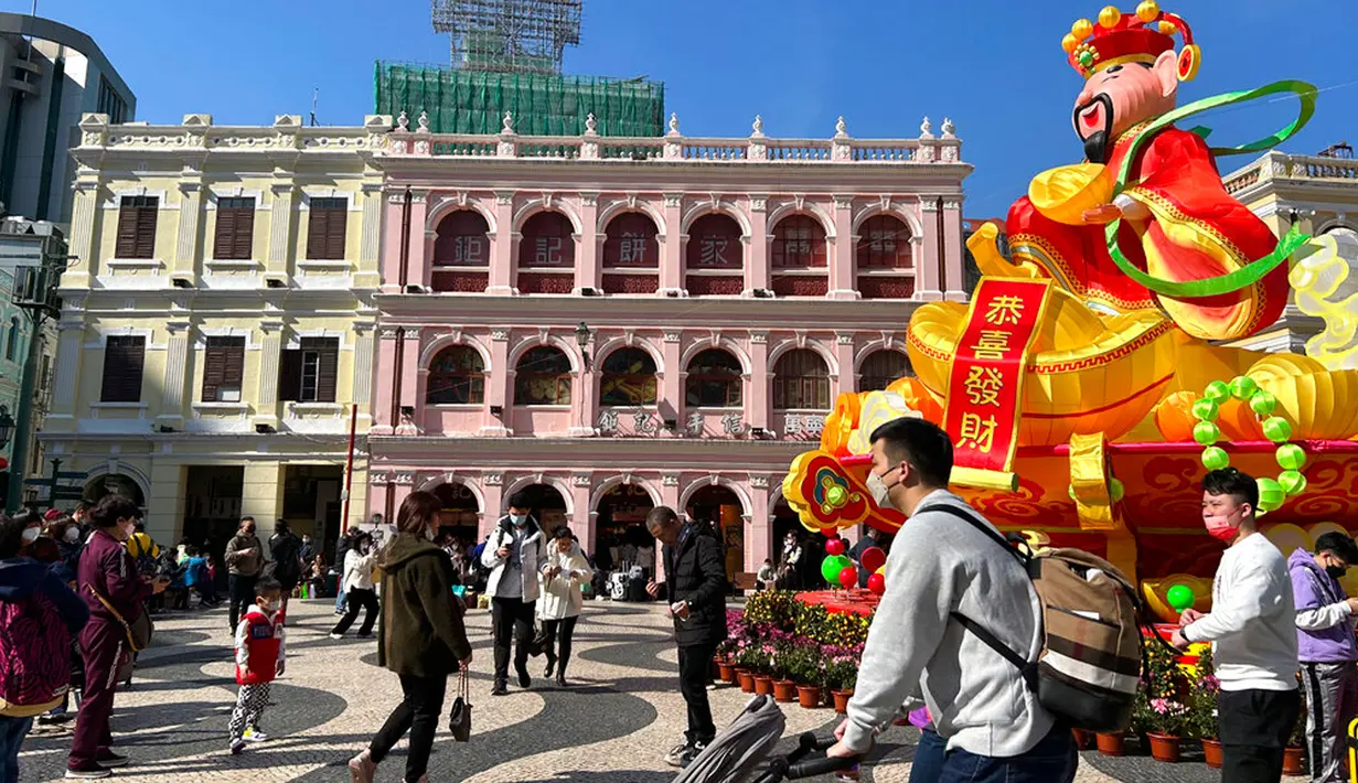Pelancong dari China daratan berjalan di sekitar Lapangan Senado, tujuan wisata di Makau, 18 Januari 2022. Ledakan pariwisata China yang diharapkan selama liburan Tahun Baru Imlek minggu depan tampaknya akan lebih cepat terjadi. (AP Photo/Kanis Leung)