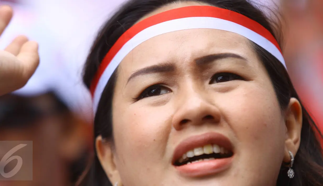Pendukung Cagub DKI Basuki T Purnama meneriakkan yel di luar ruang sidang kasus penistaan agama, Jakarta, Selasa (10/1). Dengan mengenakan atribut kotak-kotak, massa membawa bendera Indonesia serta melakukan orasi damai. (Liputan6.com/Immanuel Antonius)