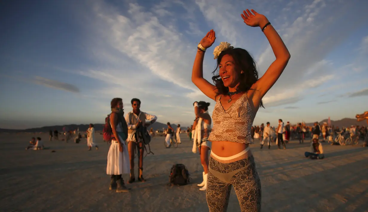 Tracy Sarita bersama pengunjung lainnya merayakan datangnya fajar dalam festival Burning Man 2015 di Gurun Black Rock, Nevada, (3/9/2015). Partisipan dari seluruh dunia hadiri festival seni unik ini selama sepekan. (REUTERS/Jim Urquhart)