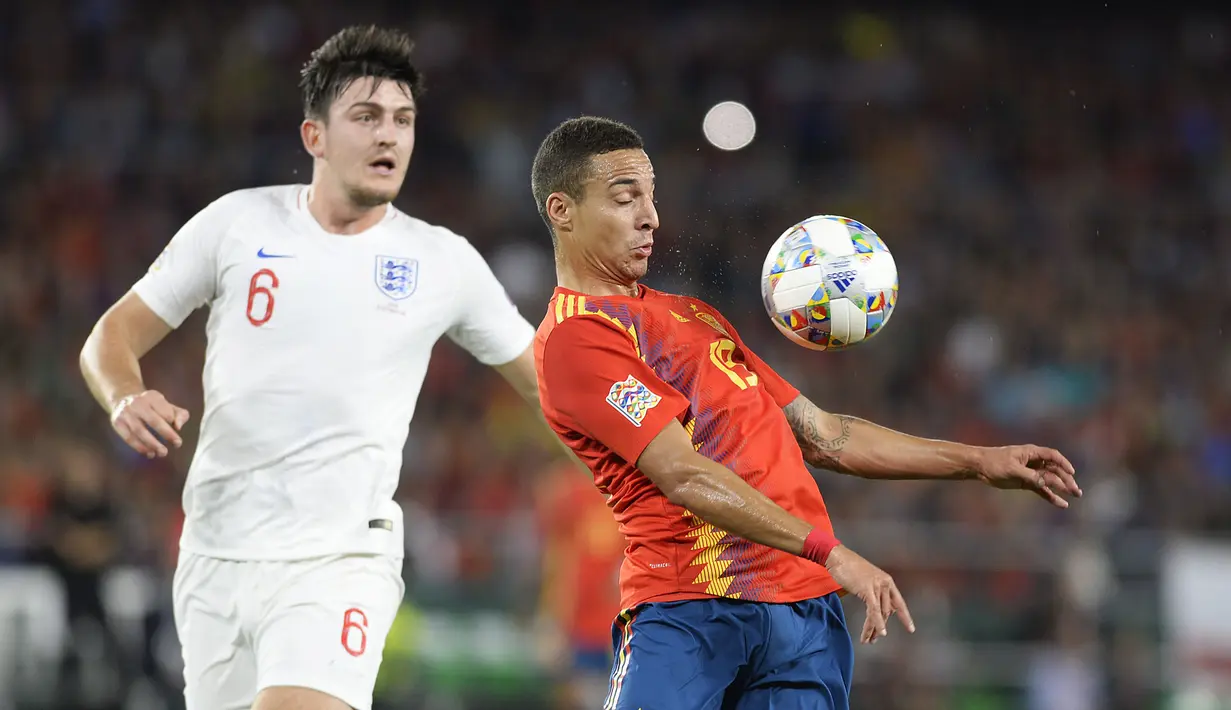 Striker Spanyol, Rodrigo, berusaha melewati bek Inggris, Harry Maguire, pada laga UEFA Nations League di Stadion Benito Villamarin, Sevilla, Senin (15/10). Spanyol kalah 2-3 dari Inggris. (AFP/Cristina Quicler)