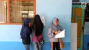 Sejumlah siswi melakukan pendataan pada hari pertama sekolah di SMP Negeri 6 Palu, Sulawesi Tengah, Senin (8/10). Pascagempa dan tsunami Palu, pihak sekolah melakukan pendataan untuk mengetahui jumlah siswa sekolah. (Liputan6.com/Fery Pradolo)