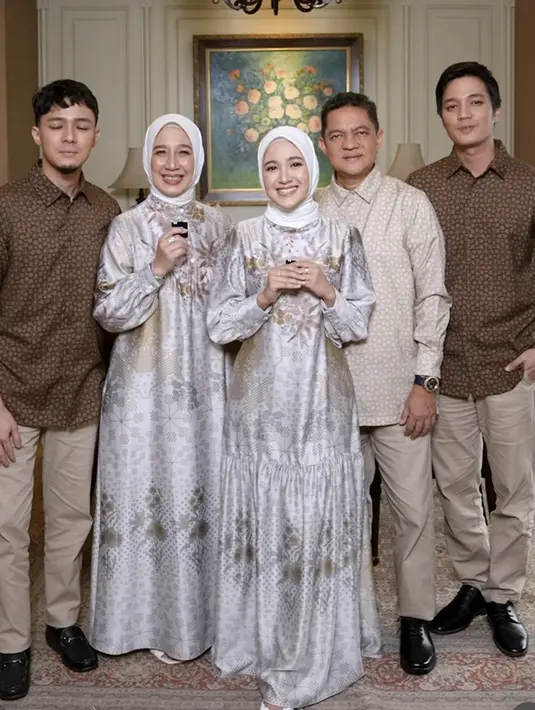 Bisa juga tampil kompak dengan keluarga saat lebaran seperti keluarga Syifa. Syifa tampil serasi dengan sang ibu mengenakan dress satin abu-abu memiliki motif bunga dipadu kerudung putih.  Credit: Instagram (@cutsyifaa)