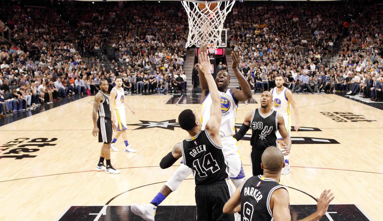 Pemain Golden State Warriors, Draymond Green (23), melakukan dunk saat dihadang pemain San Antonio Spurs, Danny Green (14), pada lanjutan NBA di AT&T Center, San Antonio, (10/4/2016). Warriors menang 92-86. (Reuters/Soobum Im-USA Today Sports)