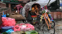 Seorang penarik becak menggunakan telepon seluler di Durbar Square, Kathmandu, Nepal pada 13 September 2025. (Arun SANKAR/AFP)