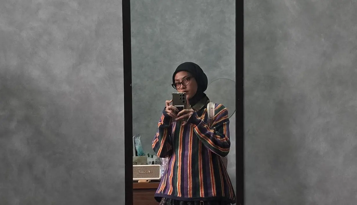 Feby Putri berani tabrak motif dan tekstur dengan paduan kemeja bergaris, rok brukat, dan celana jeans [@fbyputrinc]