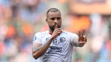 Selebrasi pemain Arema FC, Gustavo Almeida Dos Santos, setelah mencetak gol kedua ke gawang Persija Jakarta dalam pertandingan pekan kesembilan BRI Liga 1 2023/2024 yang berlangsung di Stadion Patriot Candra Bhaga, Bekasi, Minggu (20/9/2023). (Bola.com/M Iqbal Ichsan)