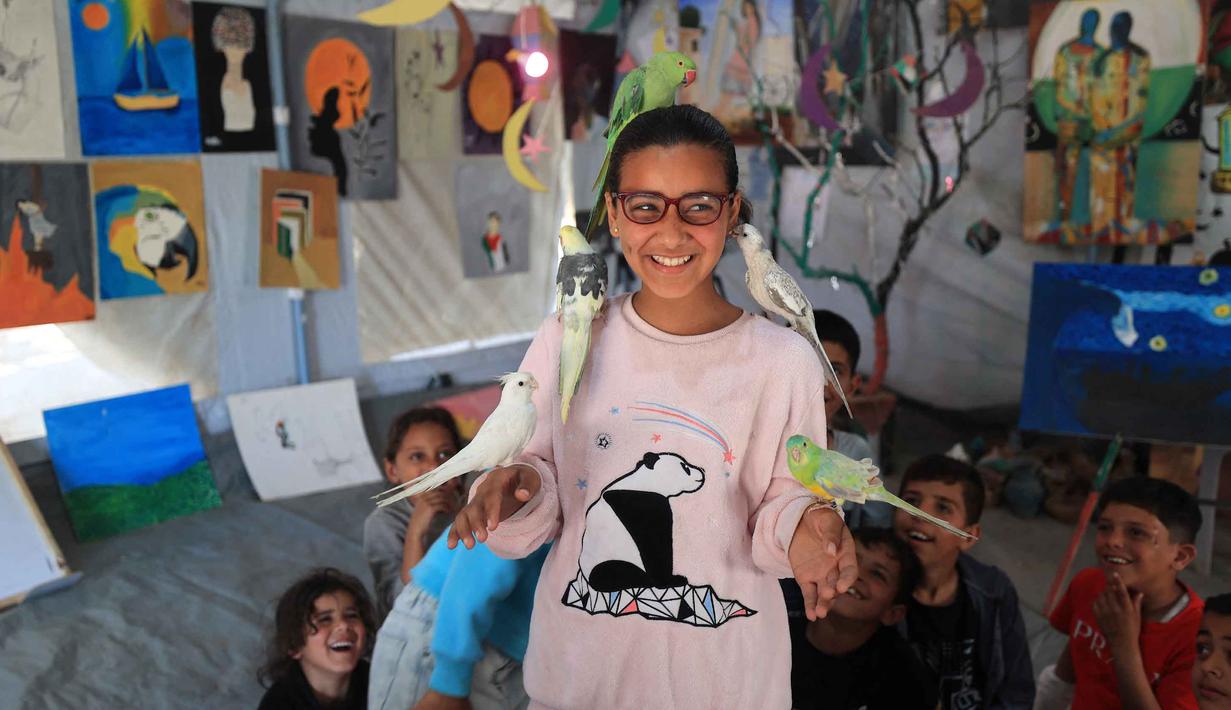 Anak-anak pengungsi Palestina mengikuti sesi dukungan psikologis di sebuah studio seni yang menggunakan hewan peliharaan dan burung di daerah Al-Zawaida, Jalur Gaza Tengah, pada Selasa 21 April 2026. Sejumlah anak-anak pengungsi Palestina mengikuti sesi konseling psikologis di sebuah studio seni di daerah Al-Zawaida, Jalur Gaza Tengah, pada Selasa 21 April 2026. (Eyad Baba/AFP)