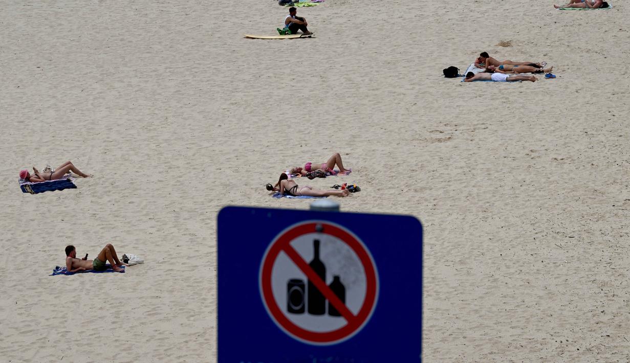 Sedikitnya 15 orang, dengan rentang usia korban antara 10 hingga 87 tahun, tewas. Tampak dalam foto, orang-orang terlihat di Pantai Bondi di Sydney, Australia pada Senin 15 Desember 2025, sehari setelah penembakan. (Saeed KHAN/AFP)