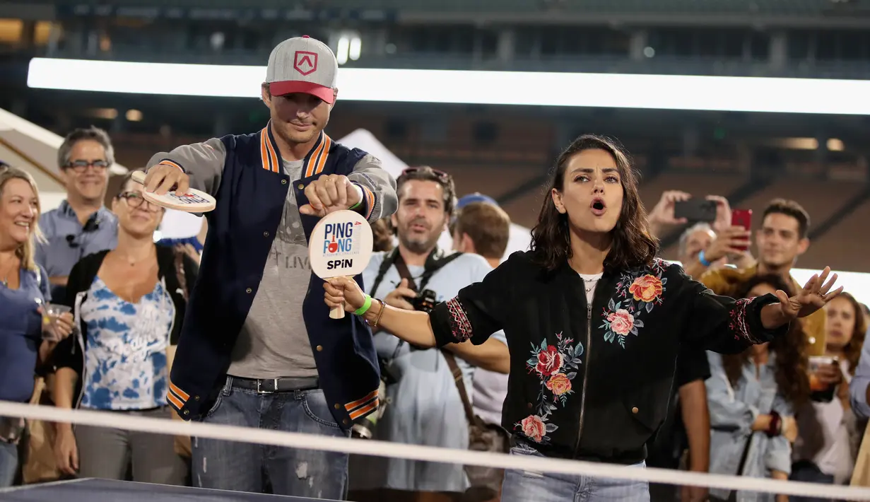 Gaya pasangan selebriti, Mila Kunis (kanan) dan Ashton Kutcher (kiri) saat bermain pingpong di acara tahunan ke-6 dari Clayton Kershaw, Ping Pong 4 Purpose, Los Angeles, Amerika Serikat, Kamis (23/8). (CHRISTOPHER POLK/GETTY IMAGES NORTH AMERICA/AFP)