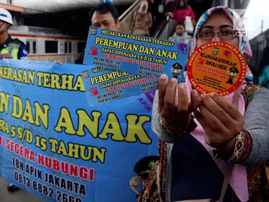 Polda Metro Jaya bekerjasama dengan LBH APIK melakukan launcing alat kampanye berupa stiker yang di bagikan kepada masyarakat pengguna Kereta di Stasiun Tanah Abang, Jakarta, Kamis (21/12). (Liputan6.com/JohanTallo)