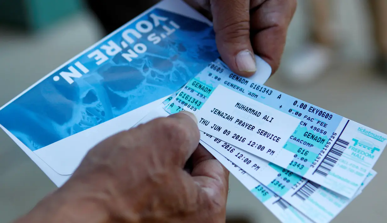 Gary Ferman menujukkan tiket pemakaman petinju legendaris Muhammad Ali yang didapat di Freedom Hall, Louisville, Kentucky, Selasa (7/6). Keluarga menyiapkan 14.000 tiket untuk acara pemakaman Muhammad Ali pada 10 Juni mendatang. (REUTERS/John Sommers II)